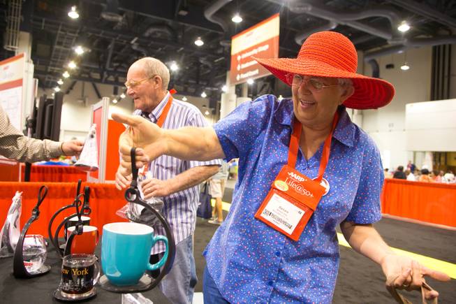 Barbara West of Boulder City demonstrates a "SpillNot" cup caddy she just purchased at the 2013 AARP Convention on Thursday, May 30, 2013.